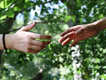 Zwei Hände strecken sich helfend einander entgegen